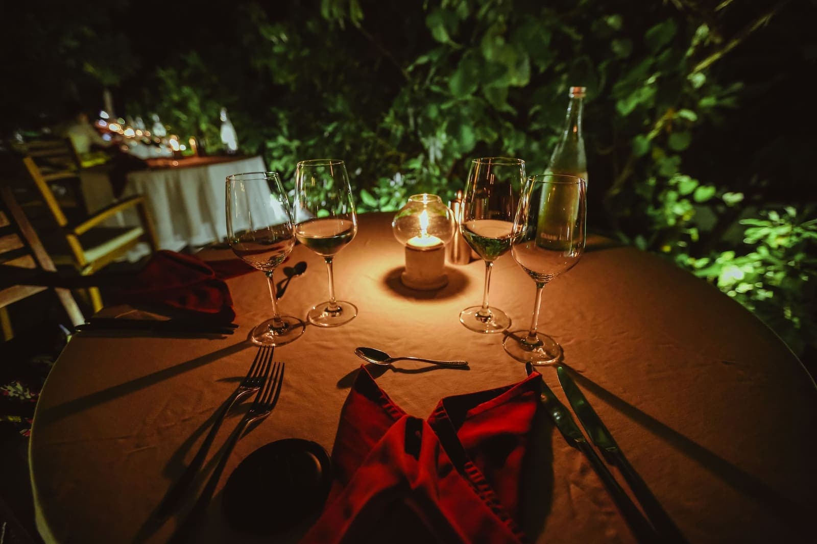 Intimate candlelit table set for two with wine glasses