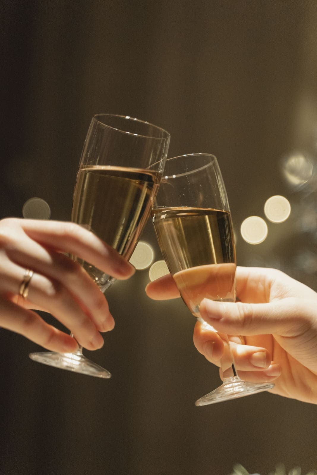 Close-up of two champagne glasses touching in a toast