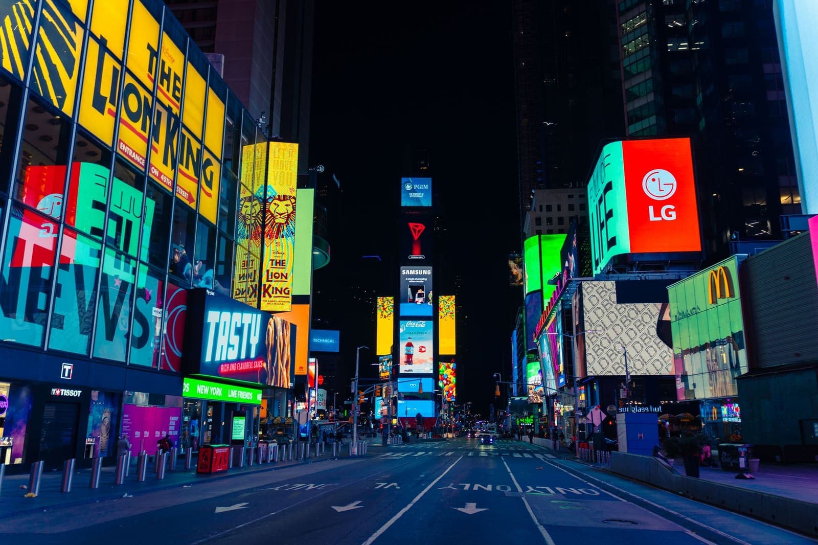 Times Square billboards lighting an almost empty Seventh Avenue at night