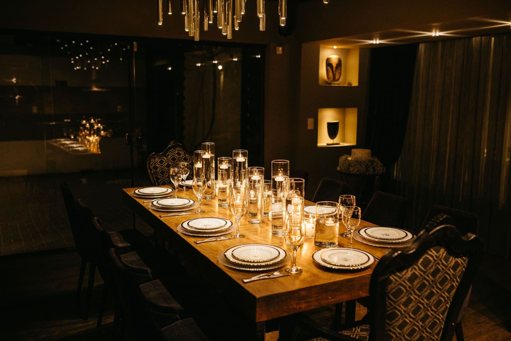 An elegant private dining room with a long candlelit table and chandelier